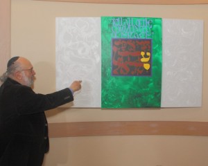 Mordechai Rosenstein stands with artwork he created for Adath Israel's 90th anniversary